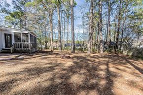 Midway Park house for rent - A house is surrounded by trees in a wooded area.