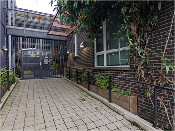 Seattle apartment for rent - A brick building with a black gate and a tiled walkway.