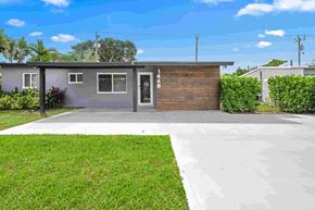 Pompano Beach apartment for rent - A modern house with a grey exterior and a wooden door.
