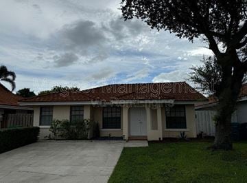 Hialeah apartment for rent - A house with a tree in front of it.