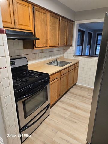 St Louis house for rent - A kitchen with wooden cabinets and a black stove top oven.