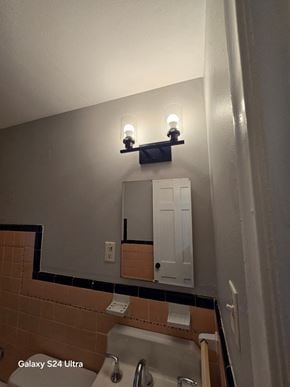St Louis house for rent - A bathroom with a Galaxy S24 Ultra phone mounted on the wall.