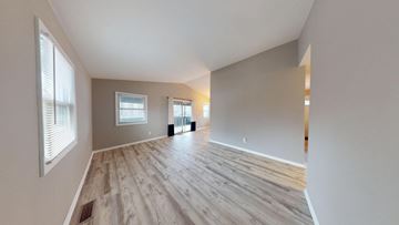 Cedar Lake house for rent - A spacious room with wooden flooring and white walls.