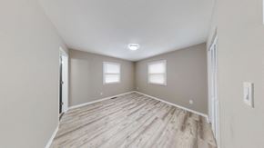 Cedar Lake house for rent - A spacious room with wooden flooring and two windows.