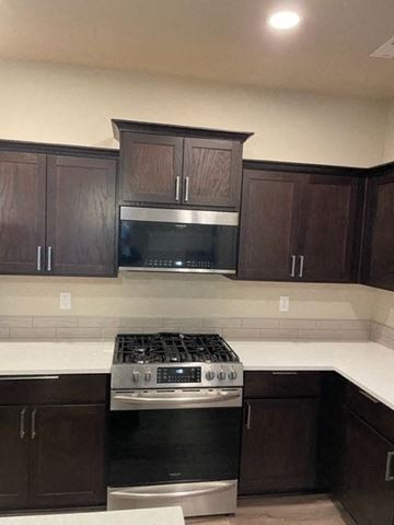 Hermiston house for rent - A kitchen with dark brown cabinets and a stainless steel oven.