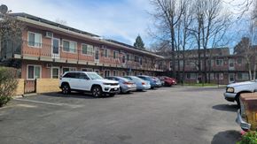 Stockton apartment for rent - A parking lot with cars and a building in the background.