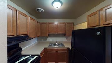 Madison apartment for rent - A kitchen with wooden cabinets and a black refrigerator.