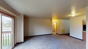 Madison apartment for rent - A spacious room with a carpeted floor and a door on the right side.