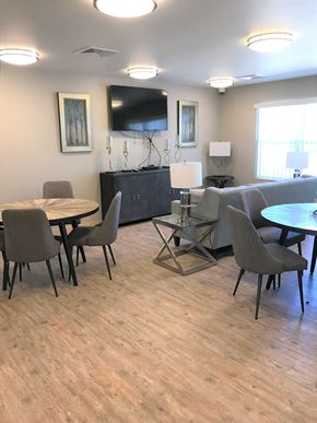 Sun Prairie apartment for rent - A living room with a grey couch, a black cabinet, and a wooden floor.