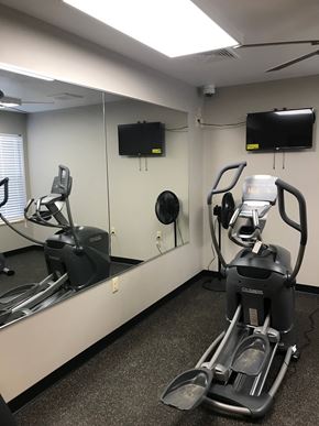 Sun Prairie apartment for rent - A gym room with a treadmill, exercise bike and a television.