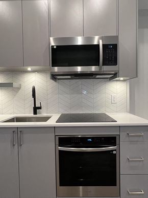 Kelowna house for rent - A modern kitchen with a stainless steel oven and microwave.