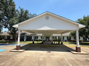 Cheneyville apartment for rent - A white covered walkway leads to a building.