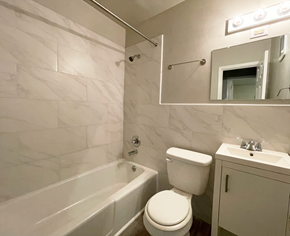 Charlotte apartment for rent - A white toilet sits next to a bathtub in a bathroom.