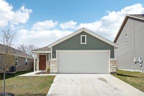Von Ormy house for rent - A house with a brown door and a grey garage door.