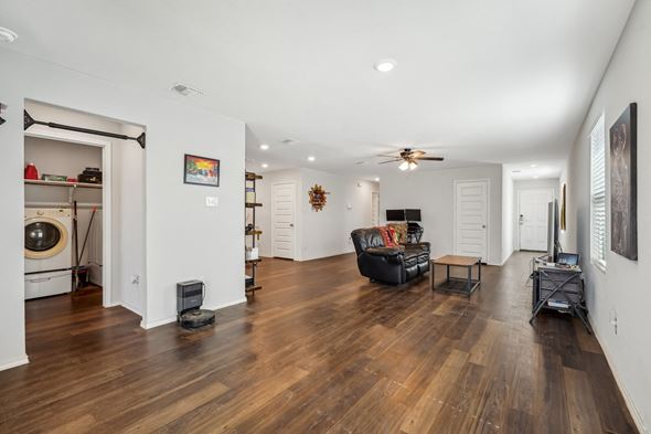 Von Ormy house for rent - A living room with a black leather couch and a ceiling fan.