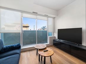 Calgary apartment for rent - A living room with a blue couch, a wooden coffee table, and a flat screen TV.