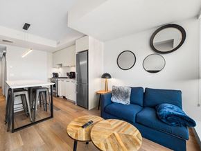 Calgary apartment for rent - A blue couch with a remote control on the table in front of it.