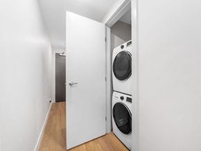 Calgary apartment for rent - A white door is open to a laundry room with a washer and dryer.