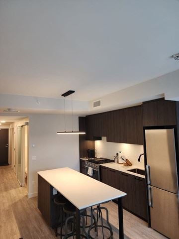 Calgary apartment for rent - A kitchen with a white table and a refrigerator.