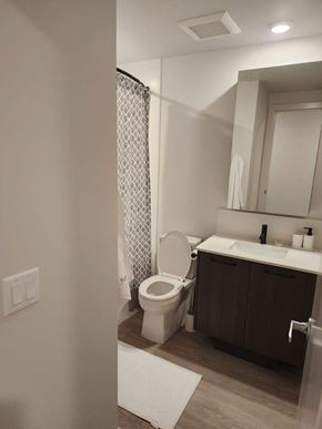 Calgary apartment for rent - A white toilet sits in a bathroom next to a sink.