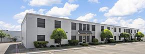 Hewitt apartment for rent - A white building with a black roof and a parking lot in front.