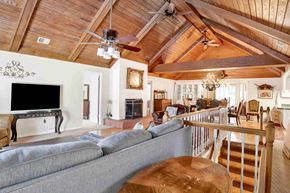 Gulf Shores house for rent - A living room with a grey couch and a wooden ceiling.
