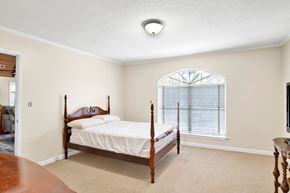 Gulf Shores house for rent - A bedroom with a bed, dresser, and window.