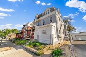 Philadelphia apartment for rent - A white two-story house with a red brick house in the background.