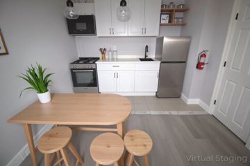 Philadelphia apartment for rent - A kitchen with a table and stools in the foreground.