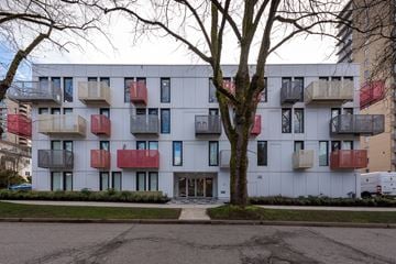 Vancouver apartment for rent - A white building with red and black balconies.