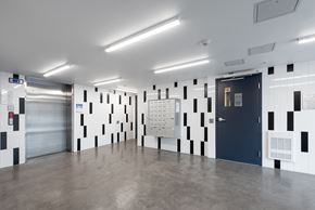 Vancouver apartment for rent - A hallway with a black and white checkered wallpaper and a blue door.