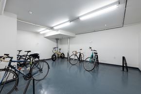 Vancouver apartment for rent - A room with a white wall and a grey floor with bicycles parked.