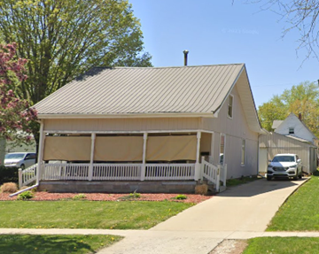 Des Moines apartment for rent - A house with a covered porch and a car parked in front.