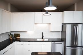 Cleveland apartment for rent - A modern kitchen with white cabinets and a black countertop.