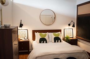 Cleveland apartment for rent - A bedroom with a white bed and two green elephant pillows.