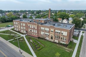 Cleveland apartment for rent - A large red brick building with a tall chimney sits on a corner lot.