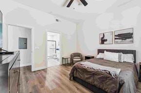 Glendale apartment for rent - A bedroom with a bed, chair, and pictures on the wall.
