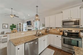 Jacksonville house for rent - A kitchen with white cabinets and a granite countertop.