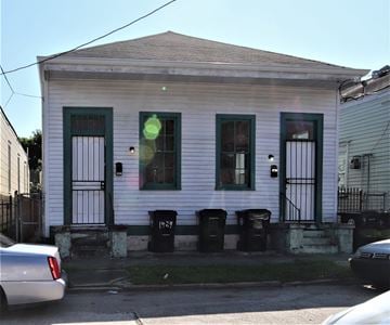 New Orleans apartment for rent - A white house with green shutters and a black gate.