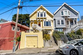 San Francisco house for rent - A white car is parked in front of a yellow house.