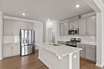 Durham house for rent - A modern kitchen with a white island and stainless steel appliances.