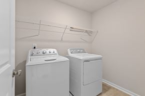 Durham house for rent - Two white front loading washing machines in a laundry room.