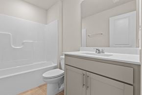 Durham house for rent - A white bathroom with a toilet, sink, and bathtub.