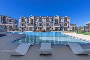 Fort Worth apartment for rent - A large swimming pool in front of a multi-story residential building.