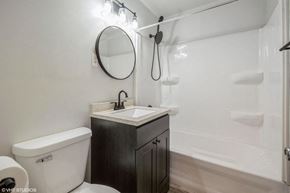 Gary house for rent - A white toilet sits next to a sink in a bathroom.