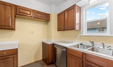Akron house for rent - A kitchen with wooden cabinets and a window.