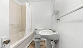 Akron house for rent - A white bathroom with a toilet, sink, and bathtub.