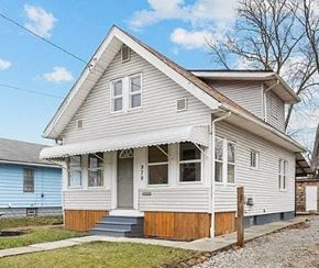 Akron house for rent - A two-story house with a grey and white exterior and a brown front porch.
