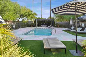 Phoenix apartment for rent - A pool with a bench and a striped umbrella.
