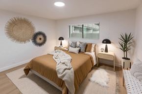 Phoenix apartment for rent - A bedroom with a bed in the center and two lamps on the side tables.